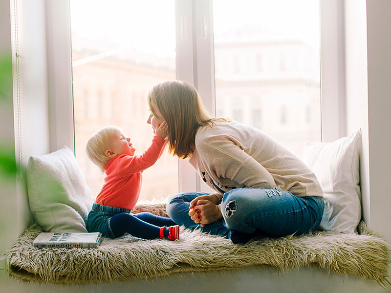 toddler touching face of a young woman